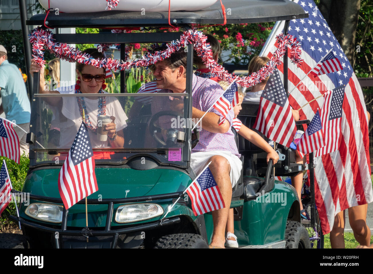A golf cart float decorated with flags during the annual Independence Day golf cart and bicycle parade July 4, 2019 in Sullivan's Island, South Carolina. The tiny affluent Sea Island beach community across from Charleston holds an outsized golf cart parade featuring more than 75 decorated carts. Stock Photo