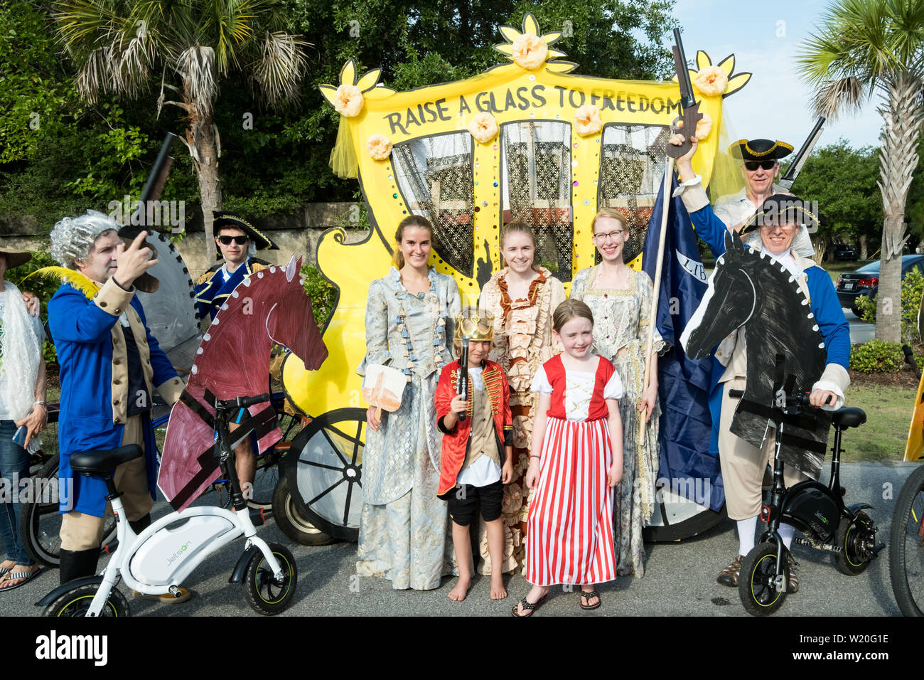 The winners of the annual Independence Day golf cart and bicycle parade pose in front of their Alexander Hamilton themed golf cart in costume July 4, 2019 in Sullivan's Island, South Carolina. The tiny affluent Sea Island beach community across from Charleston holds an outsized golf cart parade featuring more than 75 decorated carts. Stock Photo