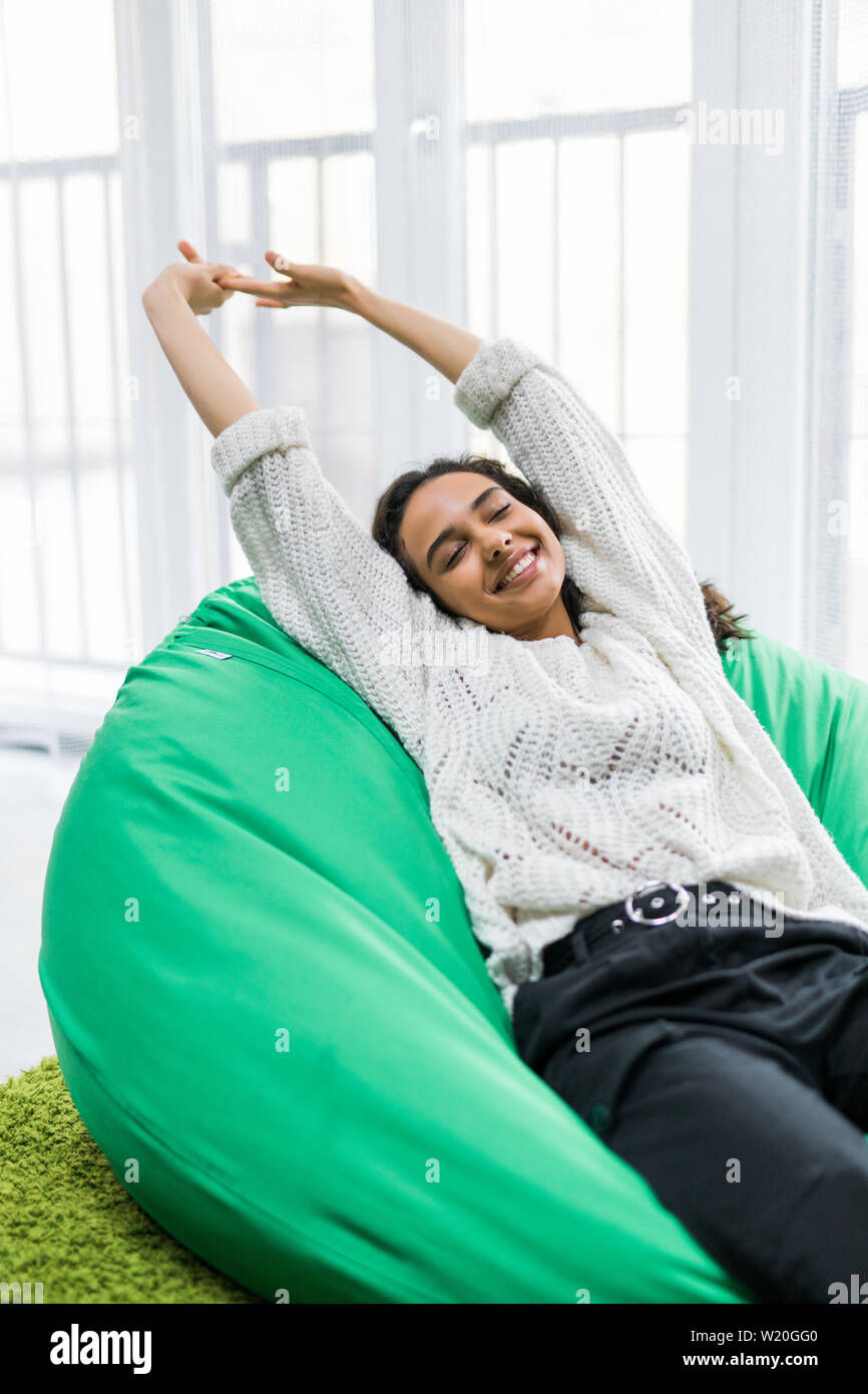 Young woman stretching while lying on the poof at home Stock Photo