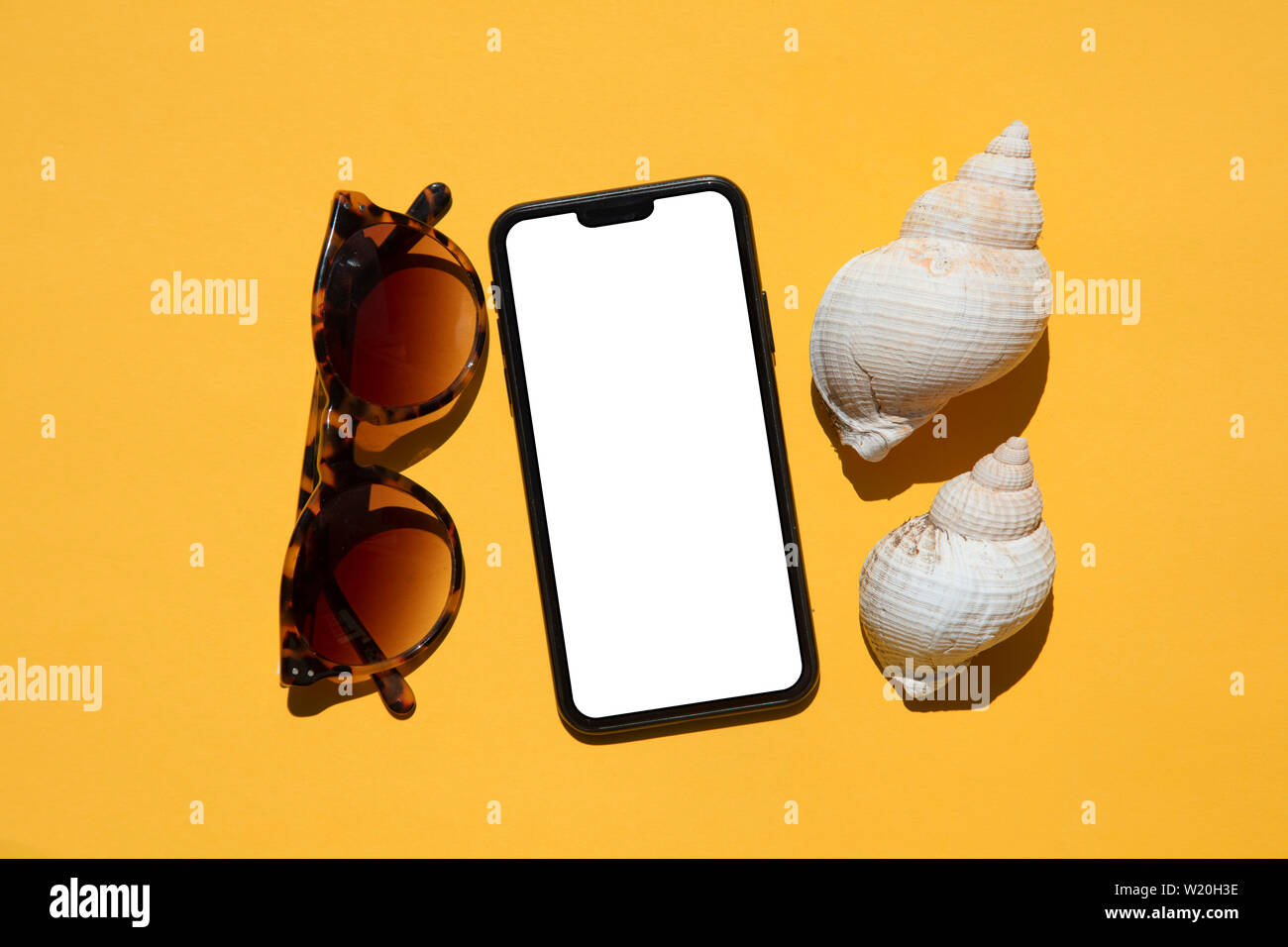 Smartphone with sunglasses and shells. Summer holiday concept Stock Photo