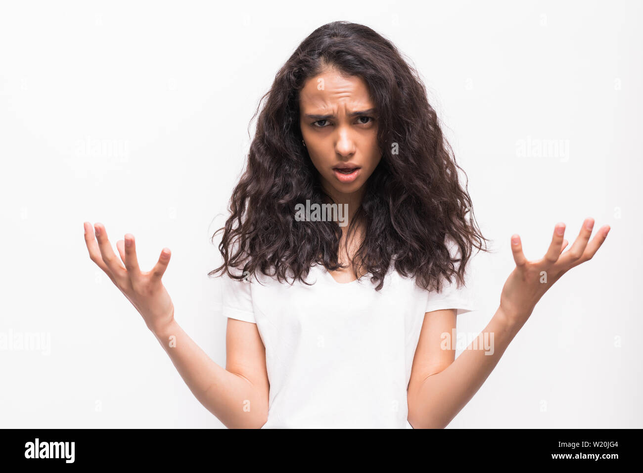 Picture of enraged dissatisfied young female grimacing, clenching teeth and making angry gesture while feeling furious at her cat that broke vase. Neg Stock Photo