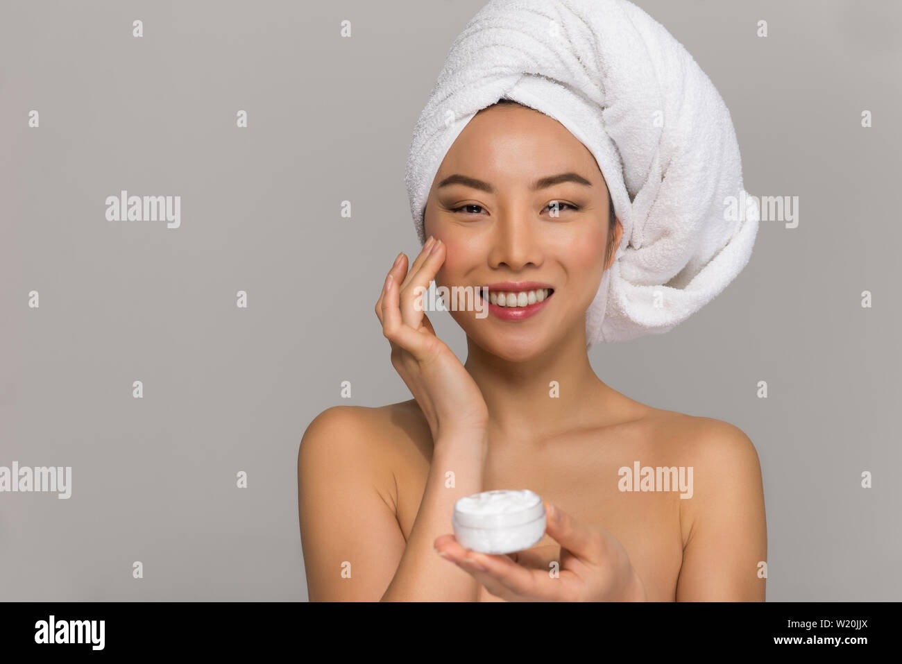 Beautiful asian woman beauty portraits. Chinese girl standing in front the mirror and taking care of her look. beauty studio shots Stock Photo