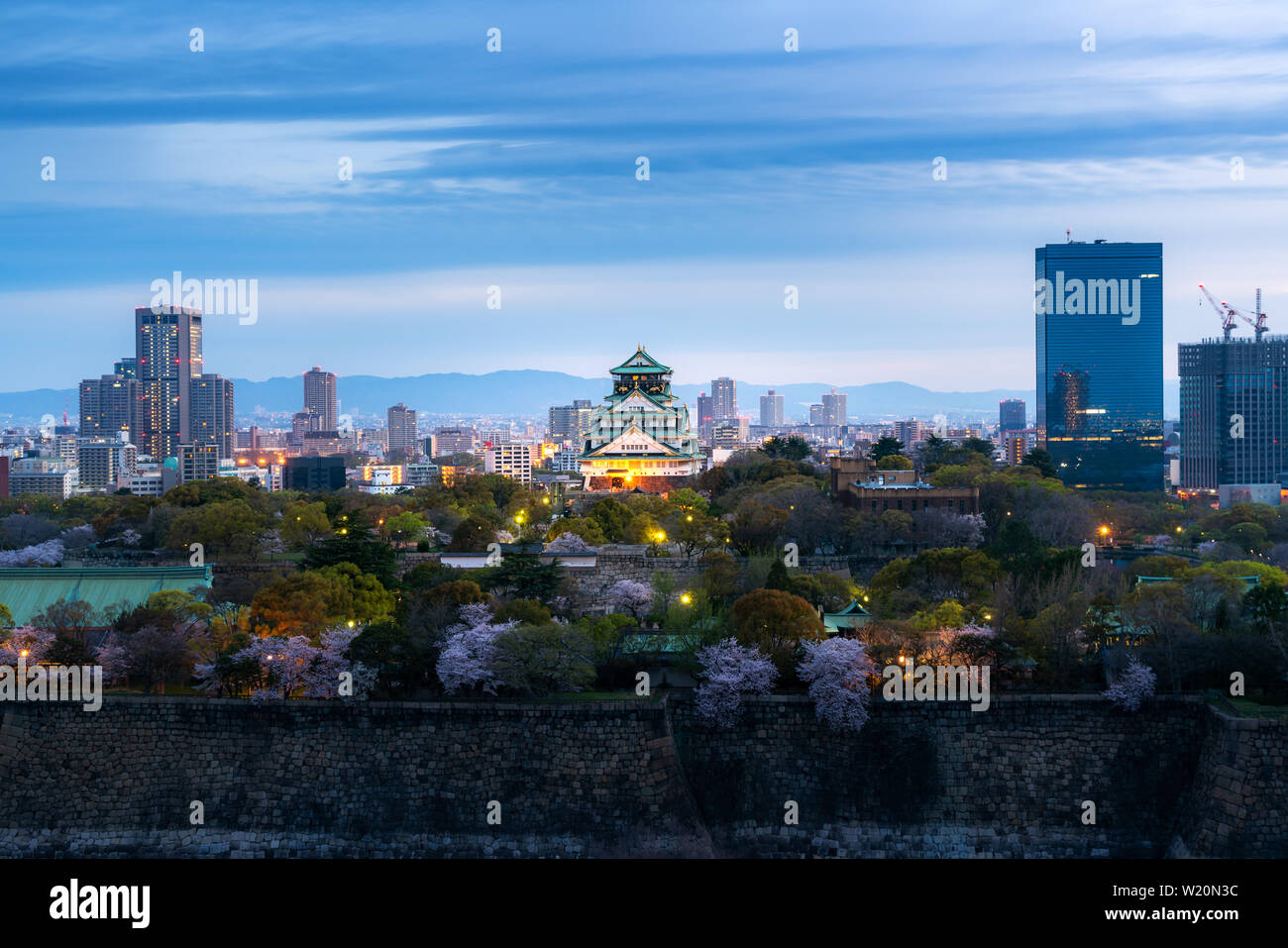 Osaka castle with cherry blossom and business district in background at Osaka, Japan. Stock Photo