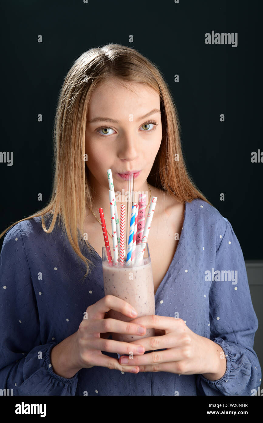 Girl drinking from non plastic biodegradable straws paper and glass Stock Photo