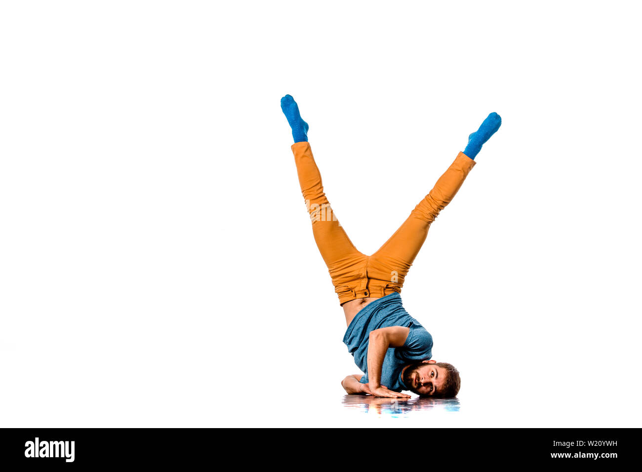 Breakdancer does expressive move and handstand isolated on white Stock Photo