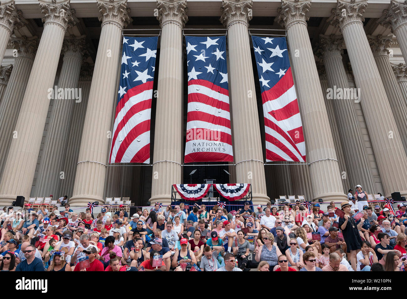 Parade-goers sit at the National Archives for the reading of the Declaration of Independence and the Independence Day Parade along Constitution Avenue in Washington DC on July 4, 2019. Credit: Stefani Reynolds/CNP/MediaPunch Stock Photo