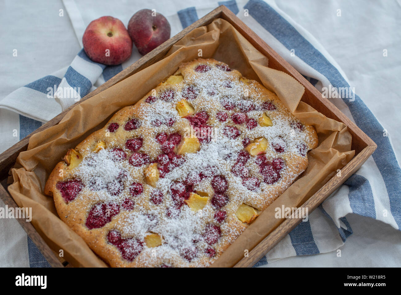 Home made almond cake with peach and raspberries Stock Photo