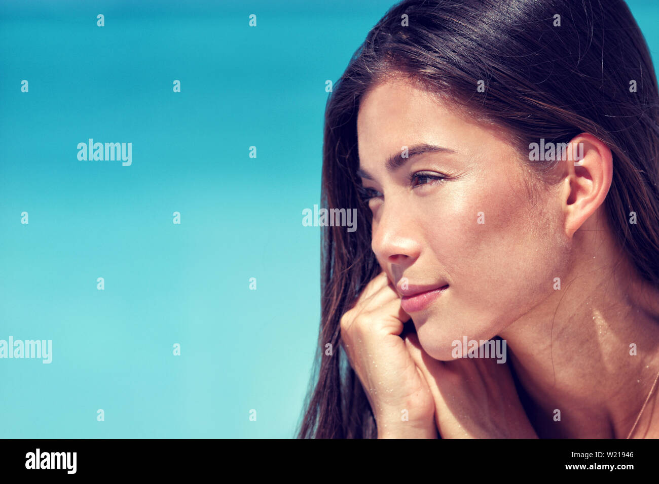 Young Asian beauty woman face closeup portrait. Mixed race Chinese Caucasian girl profile with healthy glowing skin and natural makeup on cheeks, eyelids, eyebrows, lips. Skincare concept. Stock Photo