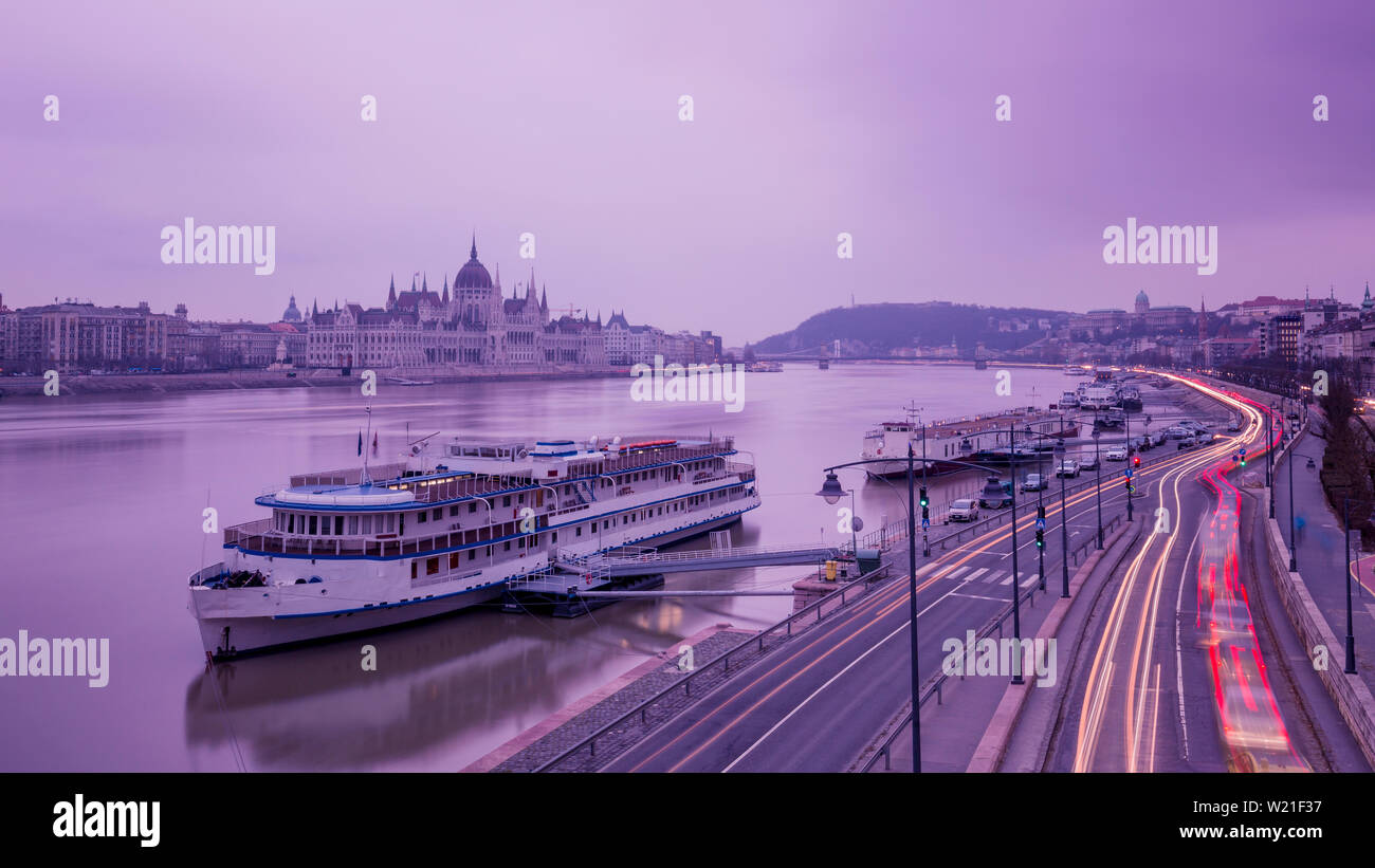Cityscape of Budapest with parliament and Danube river. Purple colors, sky reflecting in water
