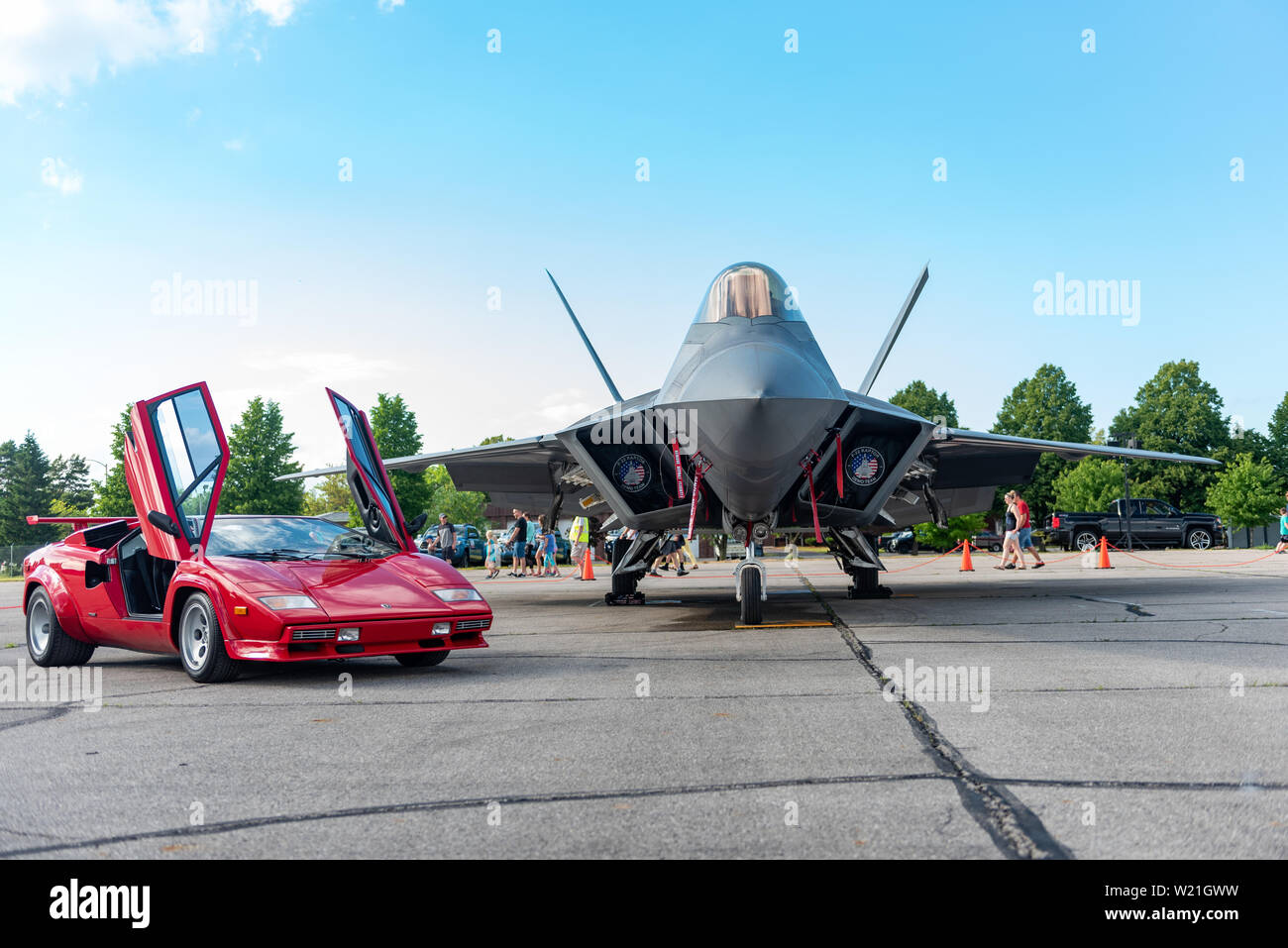 A Lamborghini Countach sits next to an F-22 Raptor during the National Cherry Festival Open House in Traverse City, Mich. June 29, 2019. Representing the U.S. Air Force and Air Combat Command, the F-22 Demo Team travels to 25 air shows a season to showcase the performance and capabilities of the world's premier 5th-generation fighter. (U.S. Air Force photo by 2nd Lt. Samuel Eckholm) Stock Photo