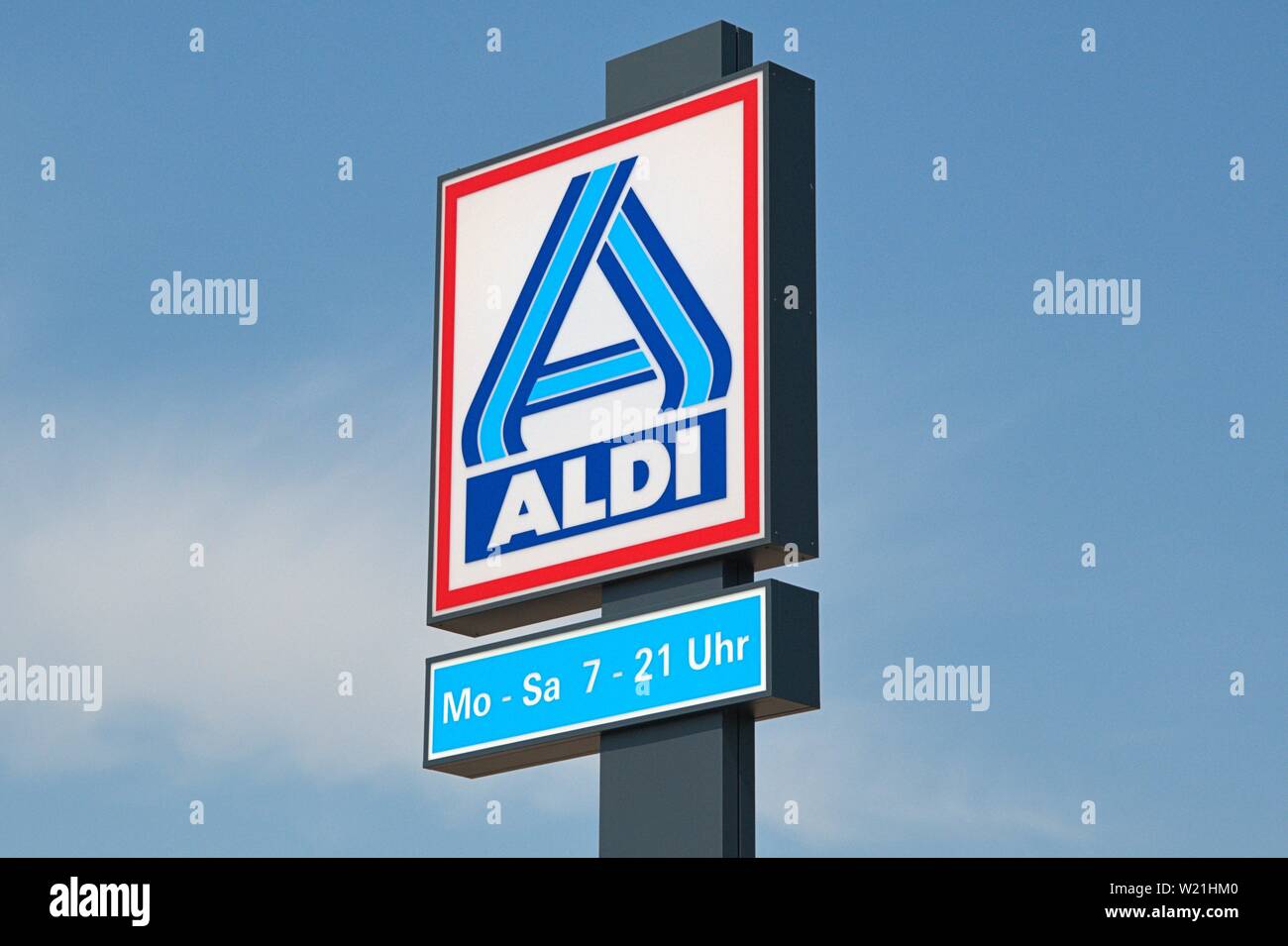 30.06.2019, the nameplate on an ALDI market in Schleswig. The neon sign of the discounters with the opening hours on a stele in front of bleuem sky. | usage worldwide Stock Photo
