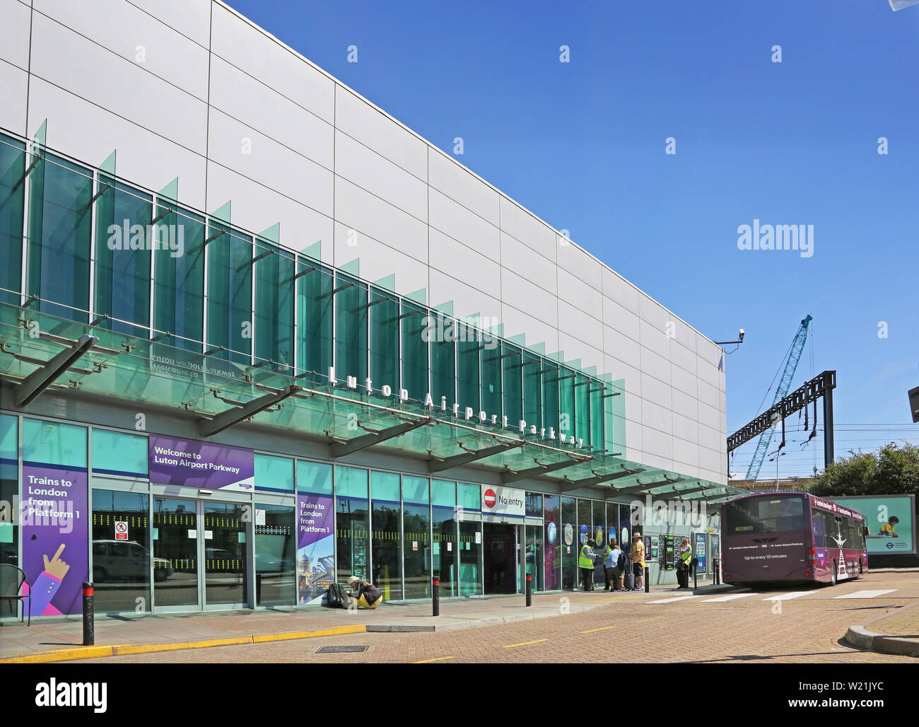 Luton Airport, London. Entrance to Luton Airport Parkway Station. Passengers wait to join the shuttle bus to the airport terminal. Stock Photo