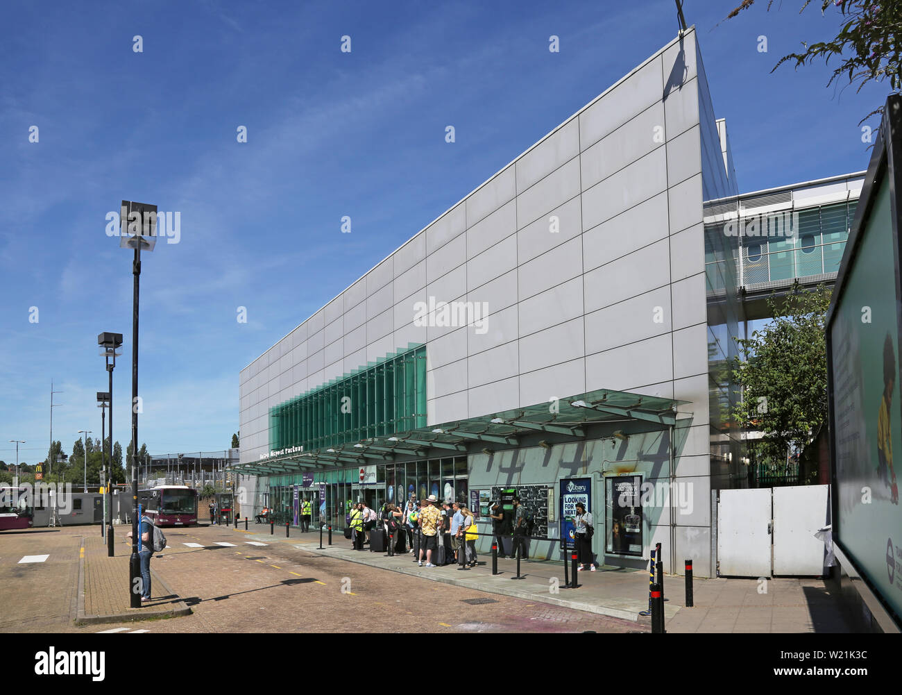 Luton Airport, London. Passengers arriving at at Luton Airport Parkway Station wait for the shuttle bus to the airport terminal. Stock Photo