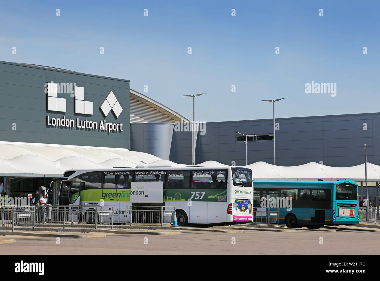 Luton Airport, London. Passenger drop-off area and bus station in front of the main terminal building - featuring new Logo (summer 2019) Stock Photo
