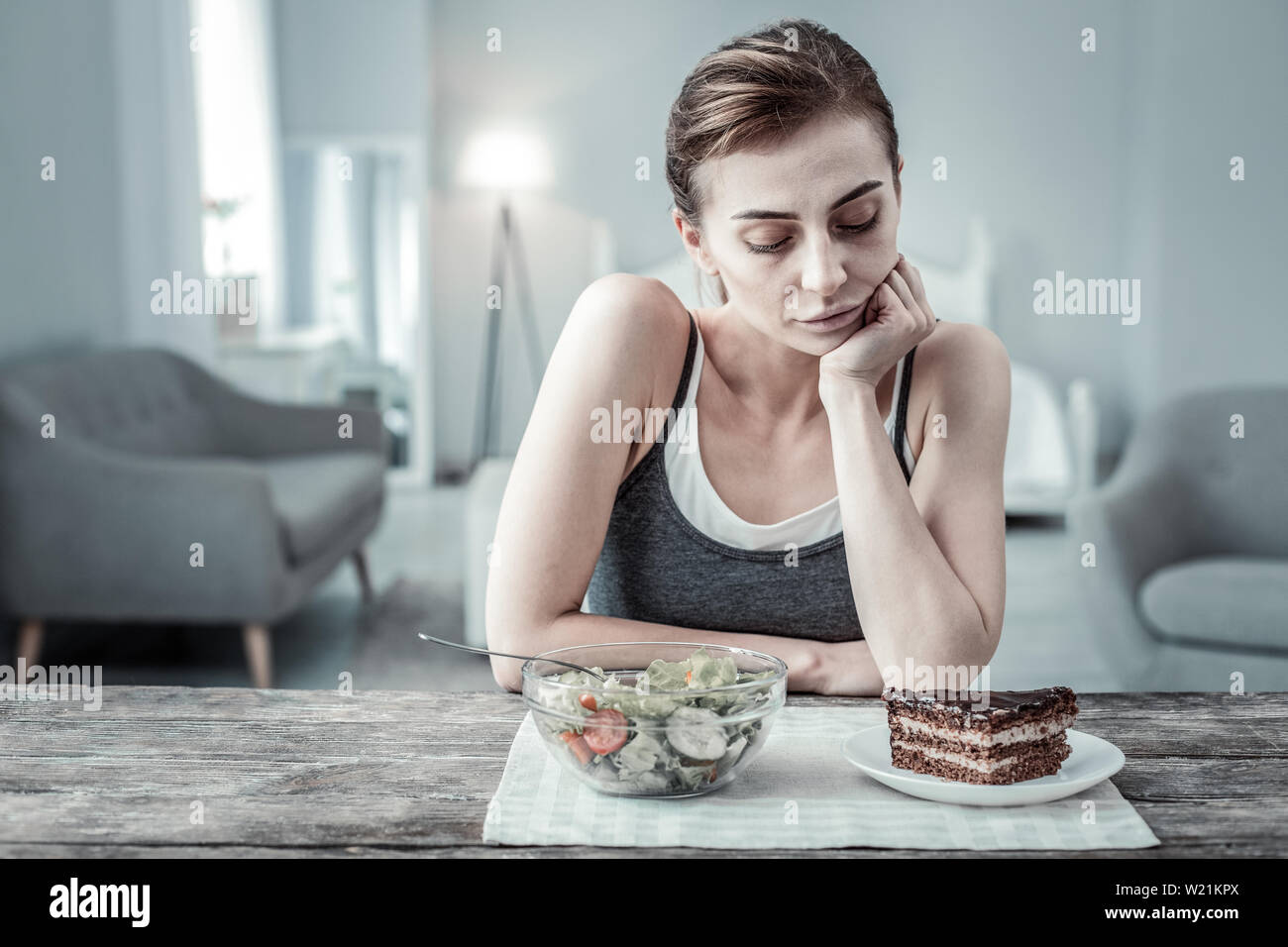 Express negativity. Dreamy girl being in kitchen while having dinner Stock Photo