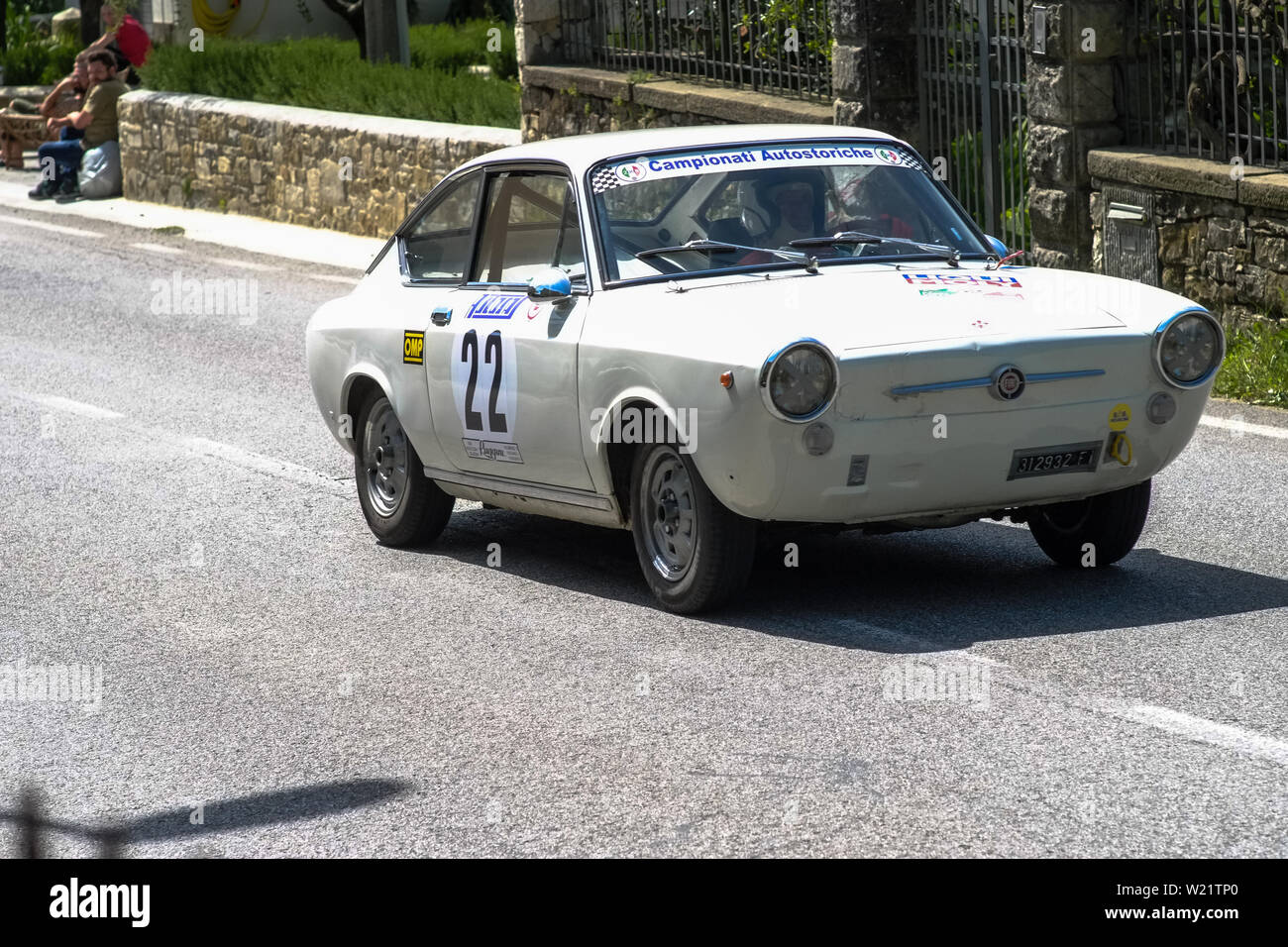 19th century old Fiat car competes for the main race with a countryside landscape around the track. Stock Photo