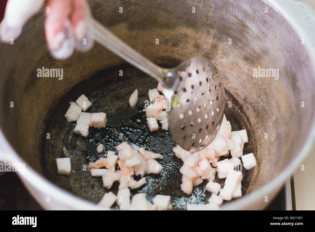 Frying fat tail in a cauldron on the stove. Heating the lard in the pan Stock Photo Alamy