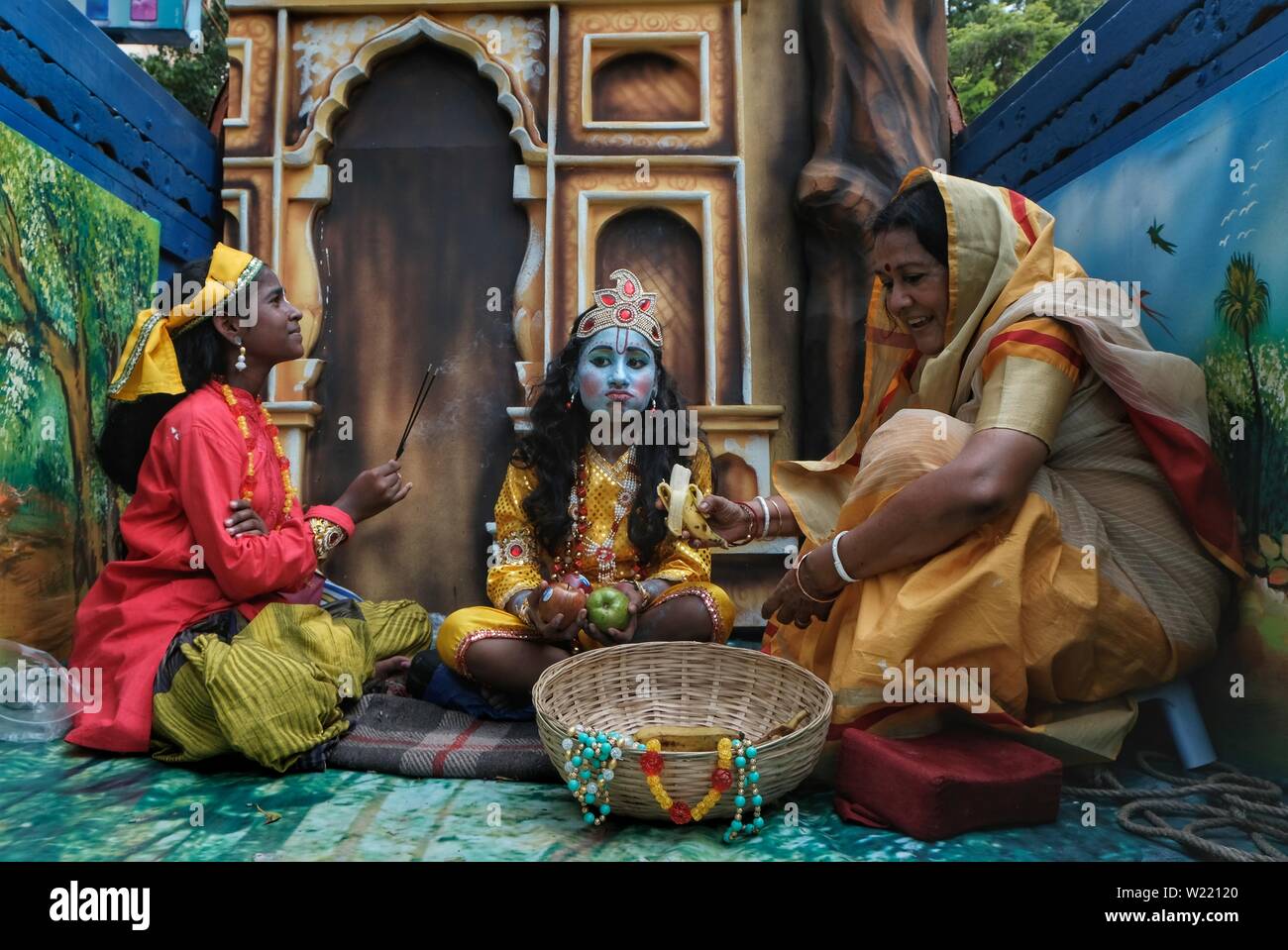 A kid disguised as child Krishna and a lady disguised as the foster