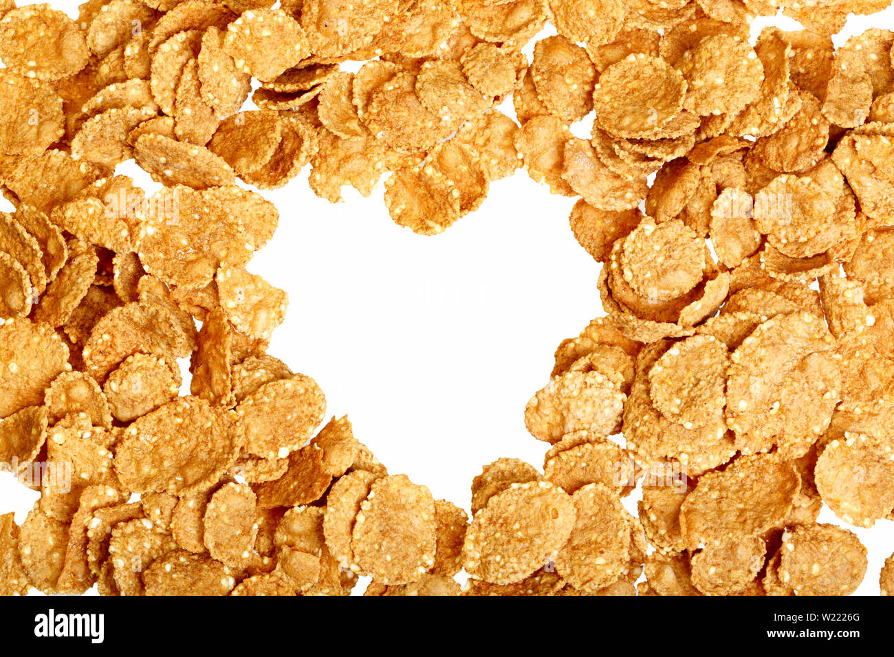 Image of heart shape made of corn flakes against white background Stock