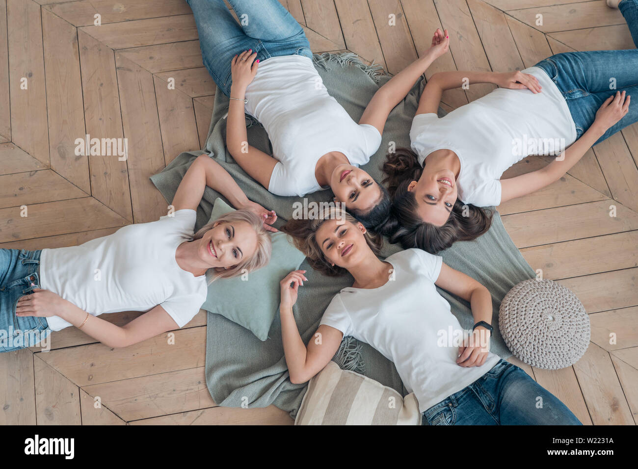 Top view of young happy girls in white t-shirts and jeans Stock Photo