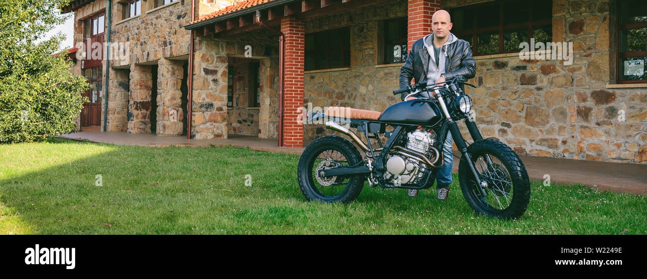 Man posing with a custom motorbike Stock Photo
