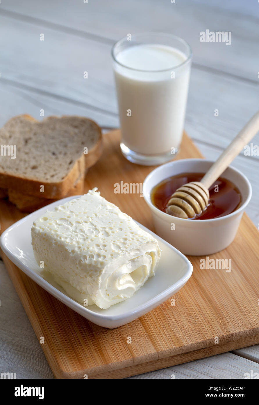 Clotted cream (butter cream) for Turkish breakfast / Kaymak, honey and glass of milk Stock Photo