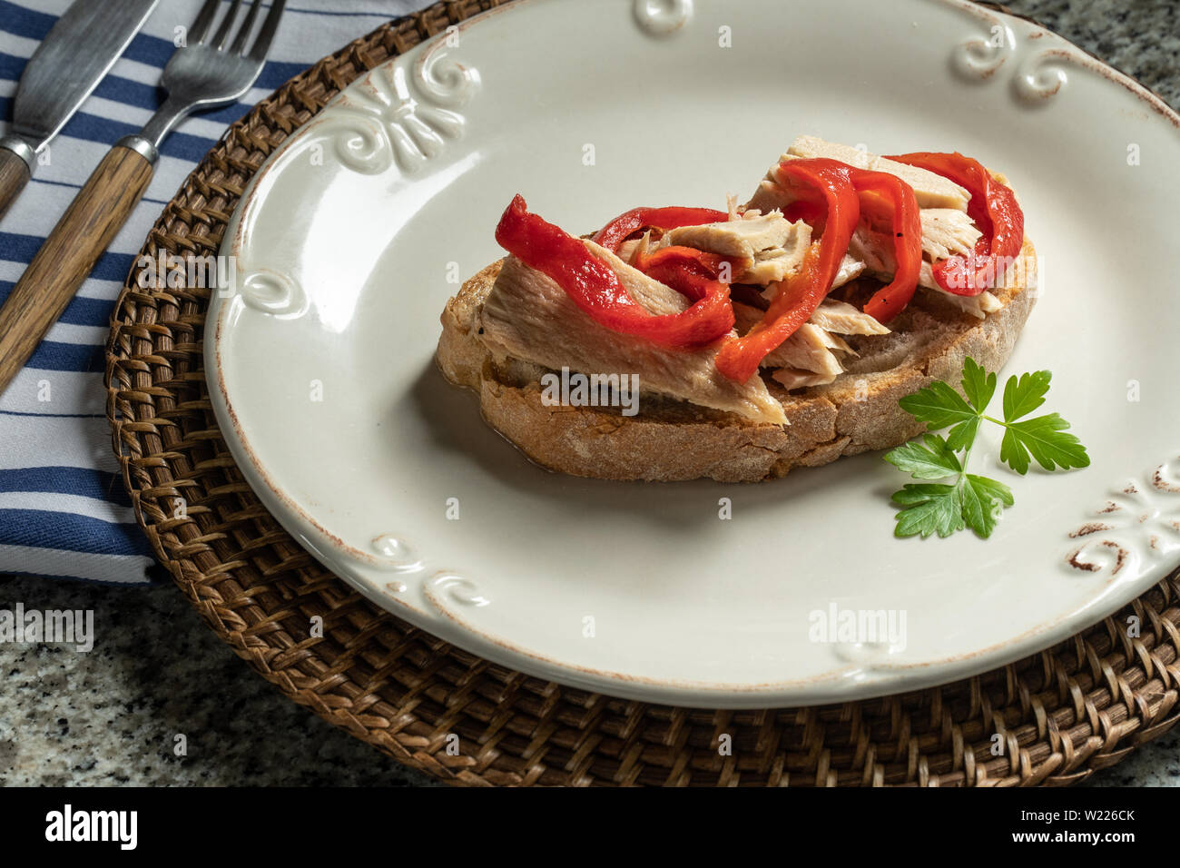 Tasty open sandwich or toast with tuna and red peppers on plate. Mediterranean cuisine Stock Photo