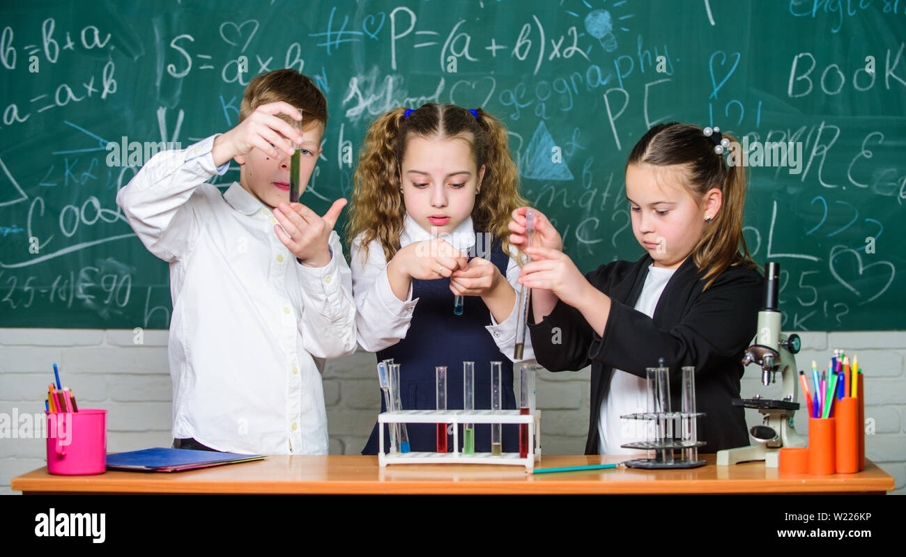 Happy children. Biology lesson. Little kids learning chemistry in lab. biology education. students doing biology experiments with microscope in lab. Biology equipment. The formula is almost complete. Stock Photo