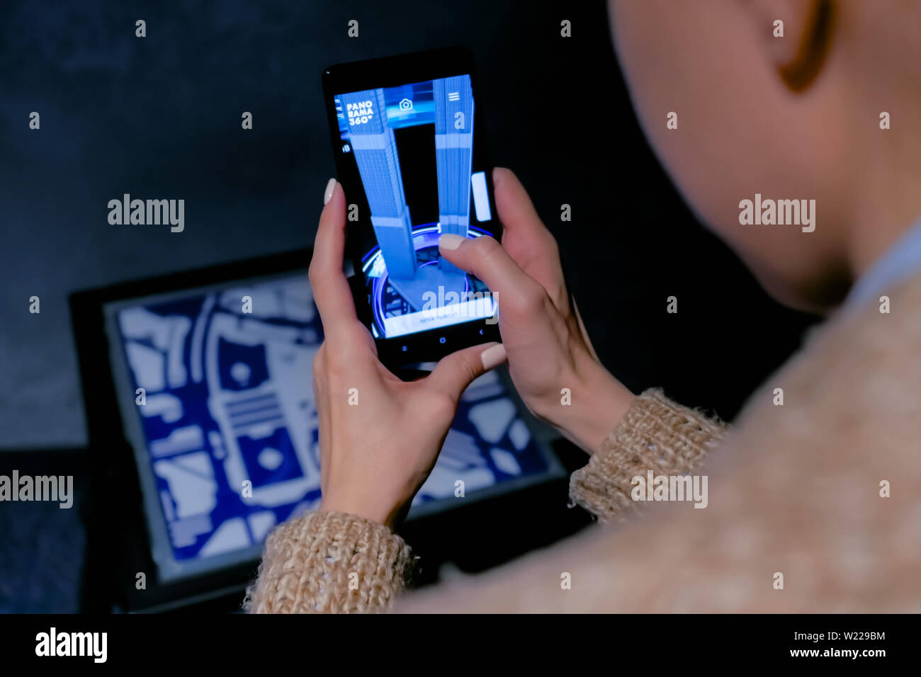 Woman using smartphone with architecture augmented reality app Stock Photo