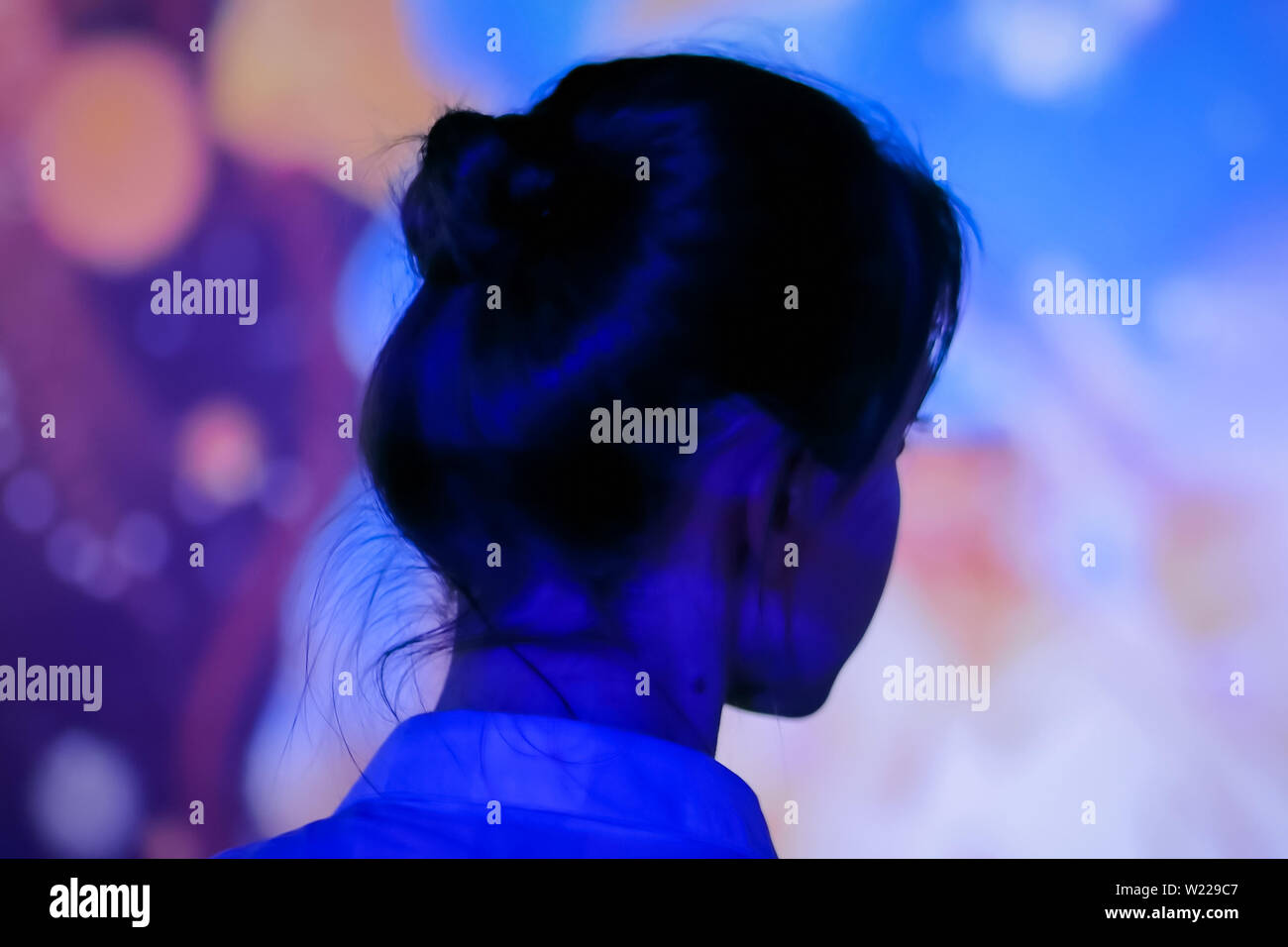 Young woman looking around at modern immersive exhibition Stock Photo ...