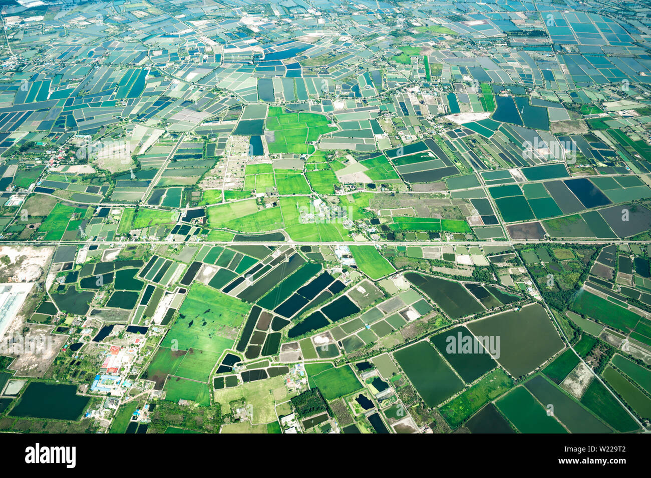 the view of green field and farm and city downtown in middle of Thailand. It shot from Jetplane. Stock Photo