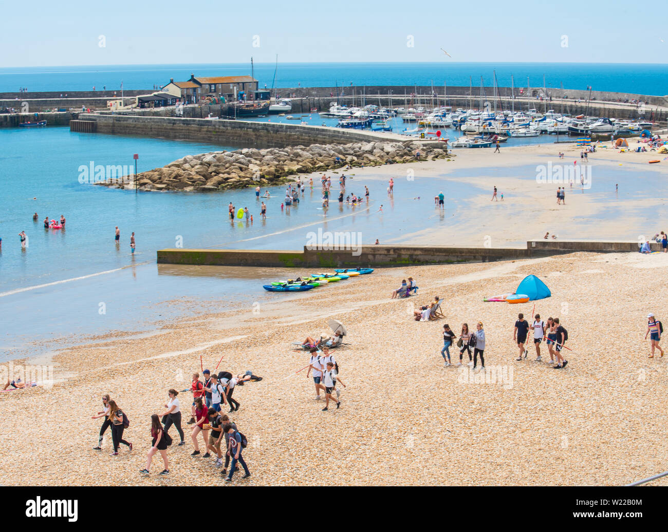 Lyme Regis, Dorset, UK. 4th July 2019. UK Weather: Sunbathers flock to the beach at the seaside resort of Lyme Regis to soak up scorching hot sunshine and blue skies ahead of the weekend. Credit: Celia McMahon/Alamy Live News. Stock Photo