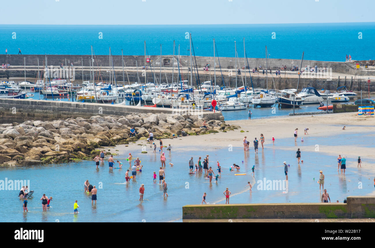 Lyme Regis, Dorset, UK. 4th July 2019. UK Weather: Sunbathers flock to the beach at the seaside resort of Lyme Regis to soak up scorching hot sunshine and blue skies ahead of the weekend. Credit: Celia McMahon/Alamy Live News. Stock Photo