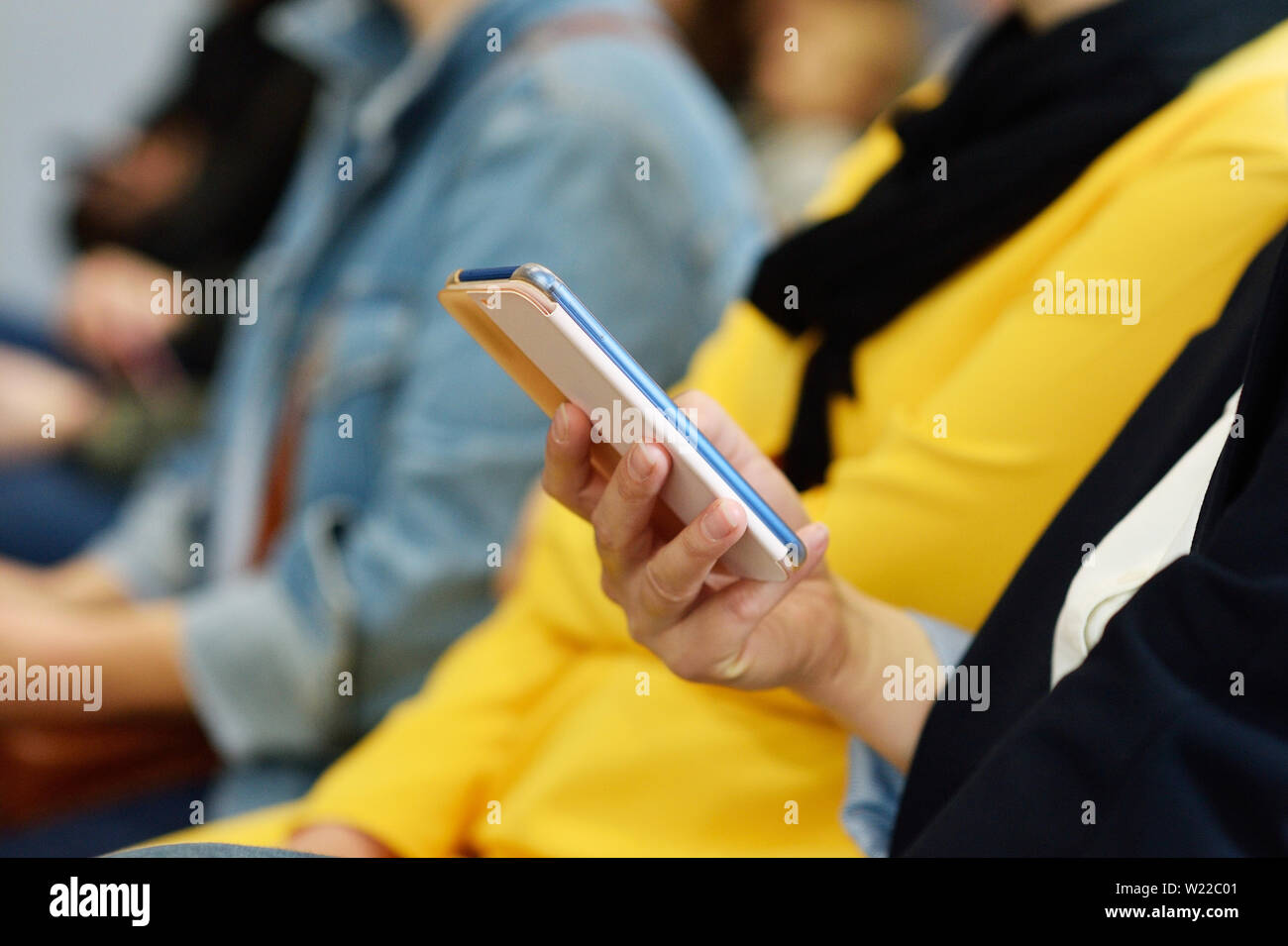Concept of phone dependency. Woman holding device and touching screen or writes a message Stock Photo