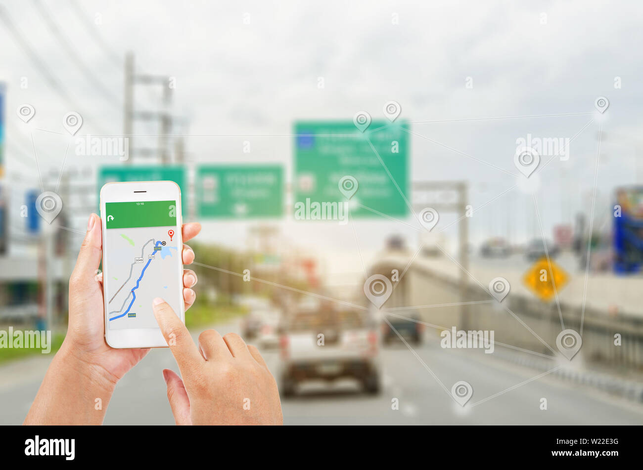 female hands holding a smart phone showing part of navigator map over screen on connection line over the road, Navigation concept. Stock Photo