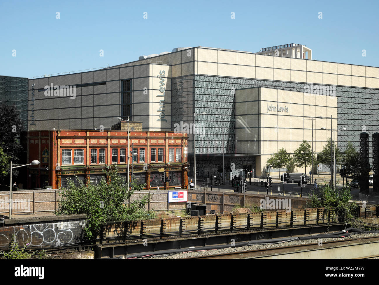 Outside view from train window of John Lewis department store and pub