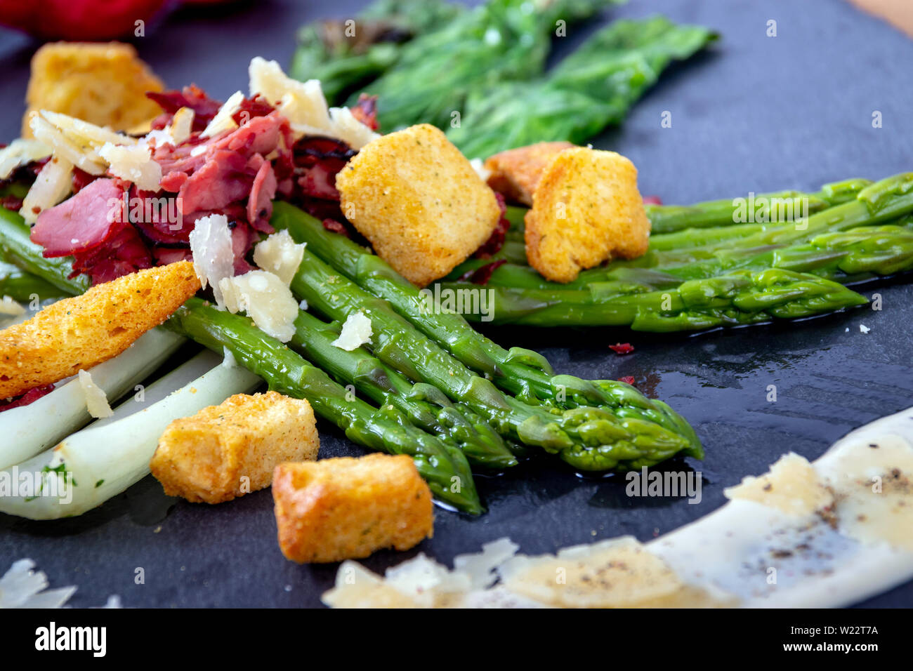 caesar asparagus with sliced parmesan cheese, smoked meat and crouton gourmet cuisine dish Stock Photo