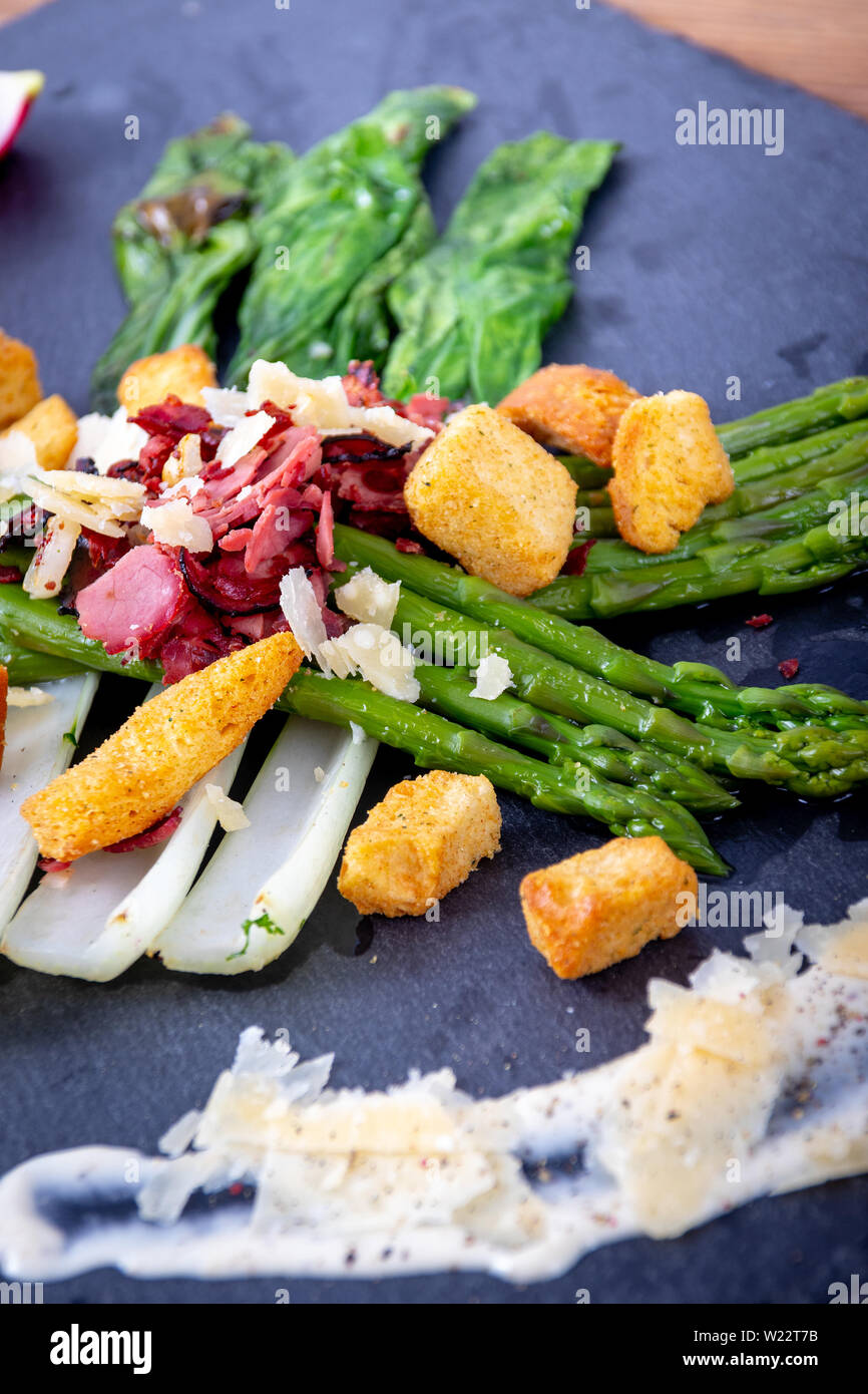 caesar asparagus with sliced parmesan cheese, smoked meat and crouton gourmet cuisine dish Stock Photo