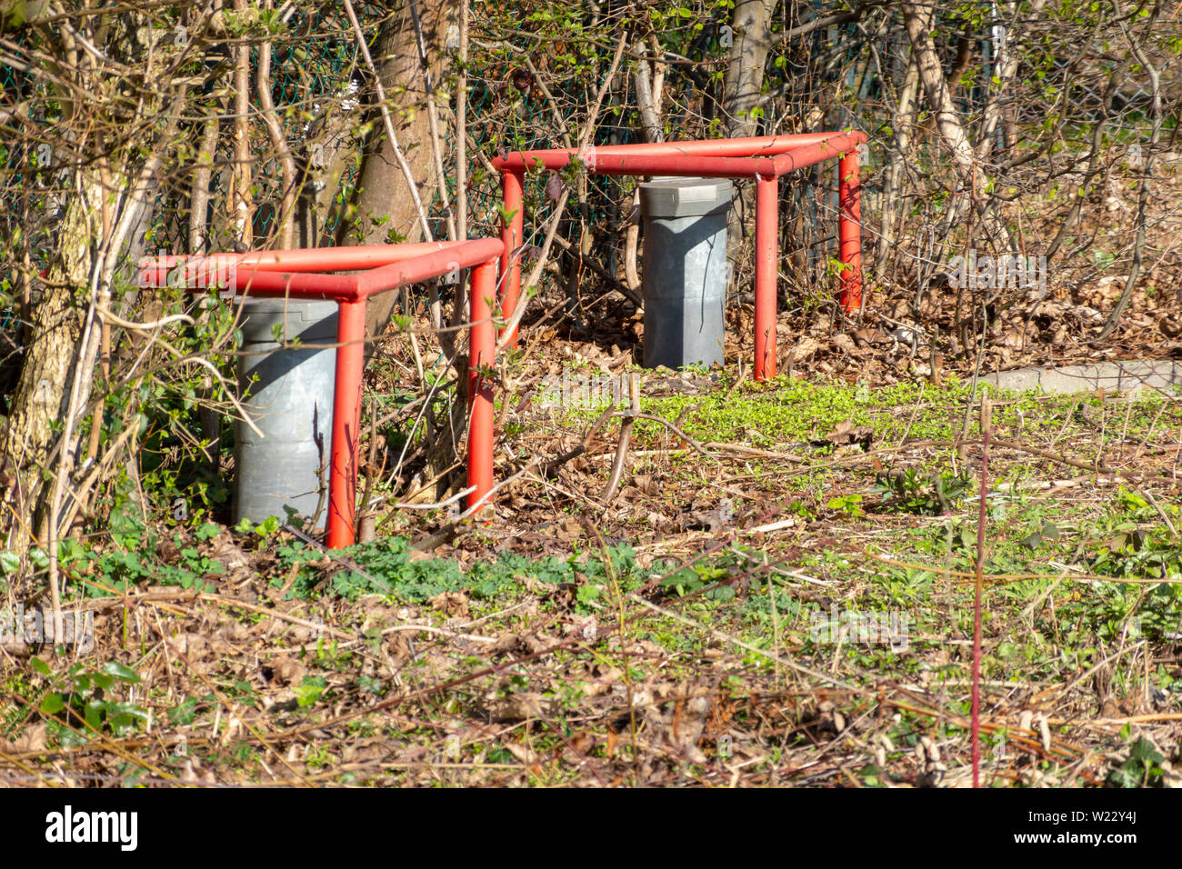 Groundwater measuring points with steel protection tube, end cap with hex locking and red protection triangle embedded in concrete, drill Stock Photo