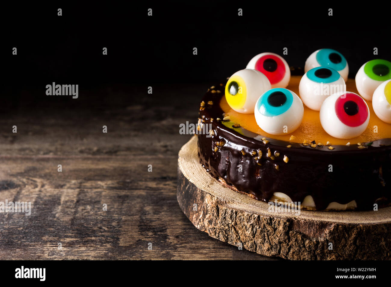 Halloween cake with candy eyes decoration on wooden table and ...
