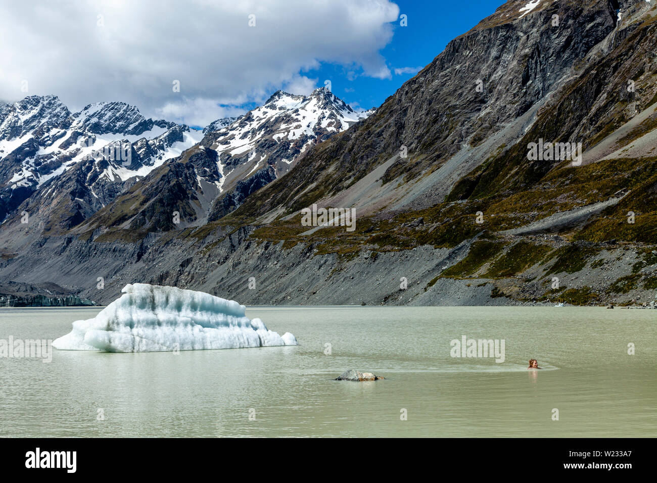A Tourist Swimming In The Glacial Hooker Lake At The End Of The Hooker Valley Track, Aoraki/Mt Cook National Park, South Island, New Zealand Stock Photo