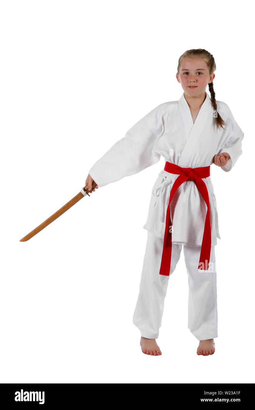 Preteen caucasian girl wearing a karate uniform performing a sword