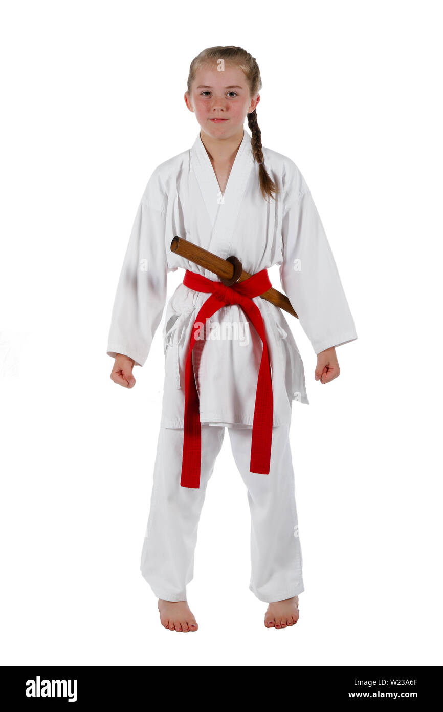Preteen caucasian girl wearing a karate uniform performing a sword