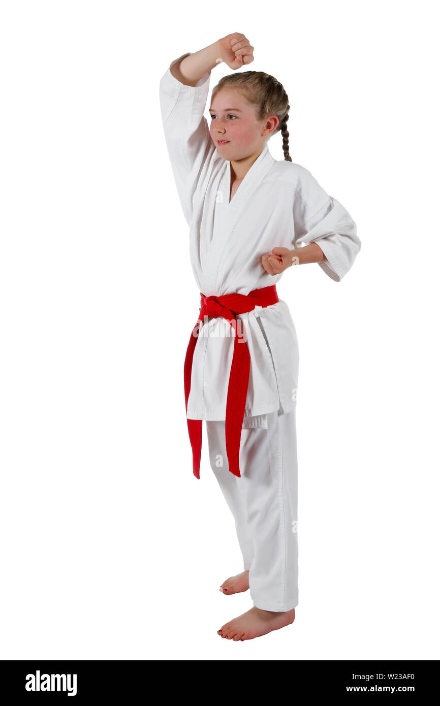 Preteen caucasian girl wearing a karate uniform doing a head block