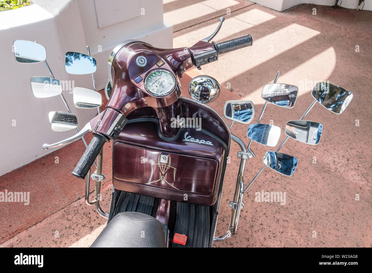 A Vespa motorscooter with 12 mirrors. Stock Photo