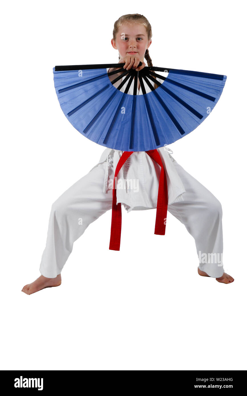 Pre-teen caucasian girl wearing a karate uniform with a fan Stock Photo