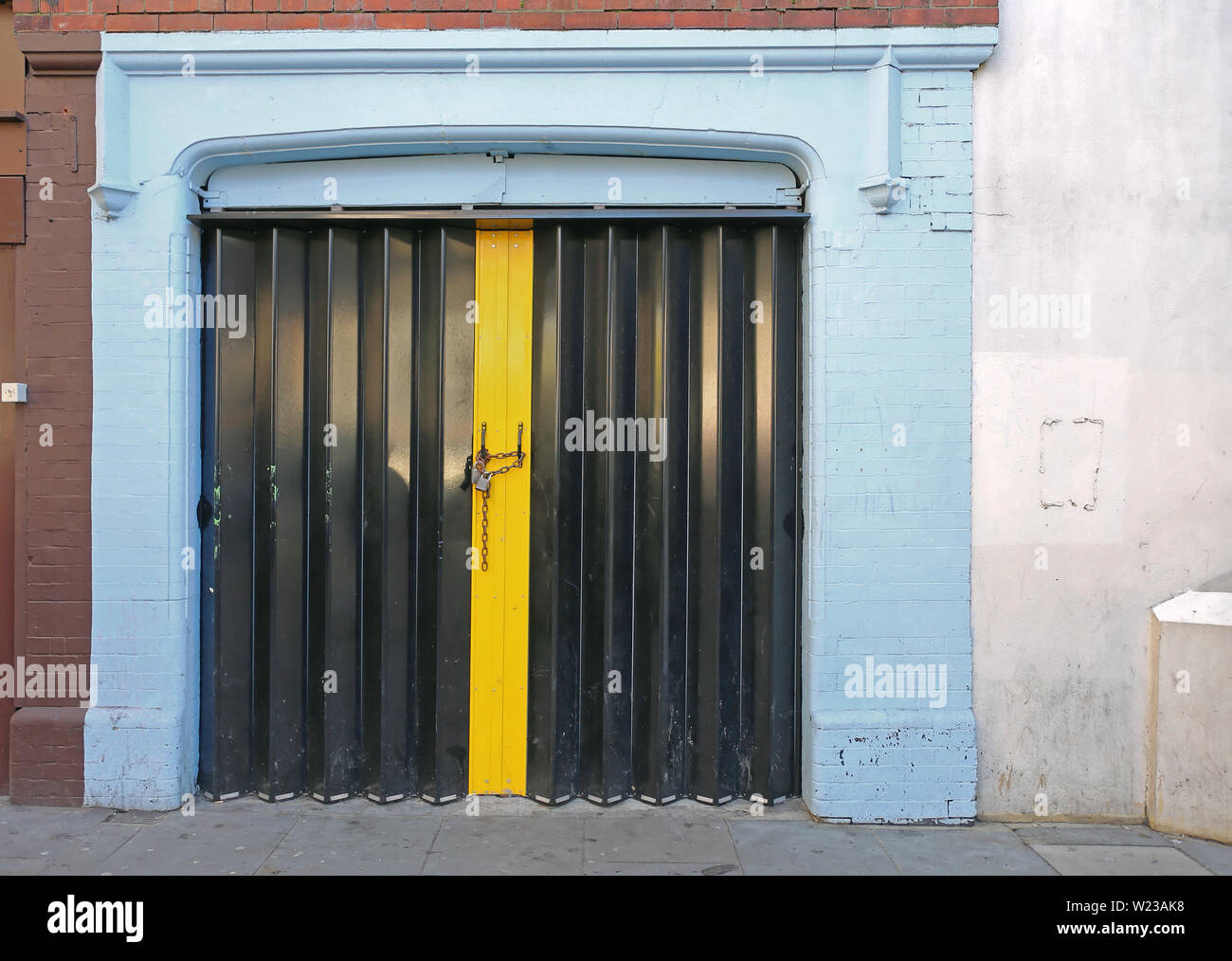 Closed Black Accordion Door Locked With Chain And Padlock Stock