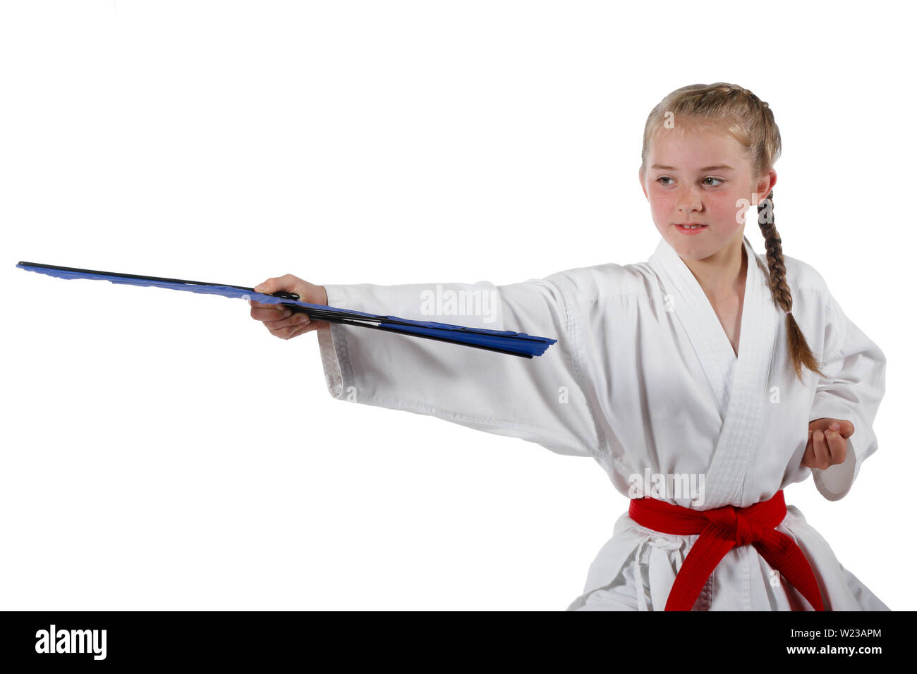 Pre-teen caucasian girl wearing a karate uniform with a fan Stock Photo
