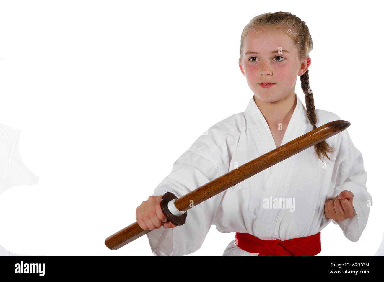 Preteen caucasian girl wearing a karate uniform performing a sword