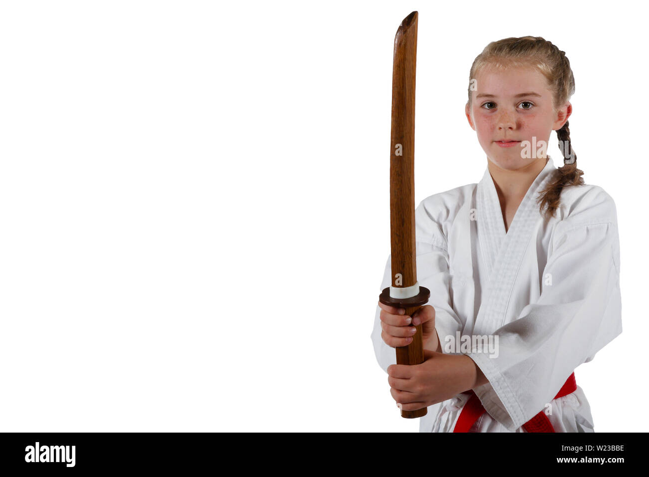 Preteen caucasian girl wearing a karate uniform performing a sword
